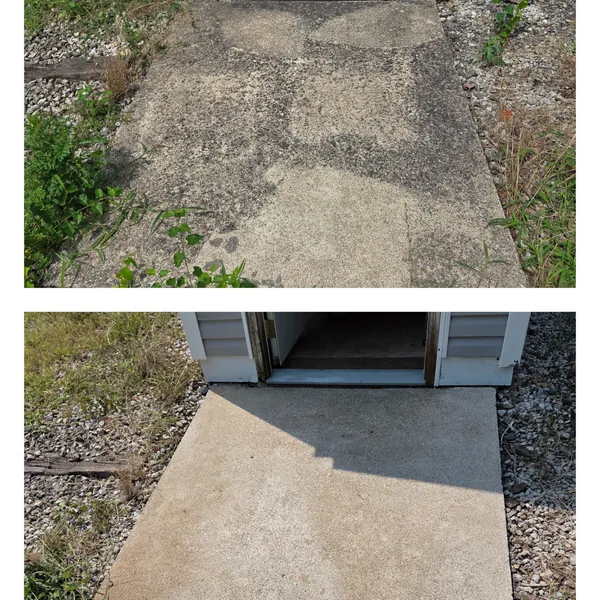 Before and after pressure washing of a moss-stained concrete path up to an outbuilding door